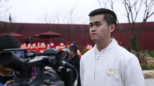 Wang Tianyi wearing a white shirt during a press interview